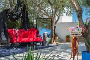 a red couch sitting on a sidewalk under a tree at Monvidal Residence - Adults Only in Pula