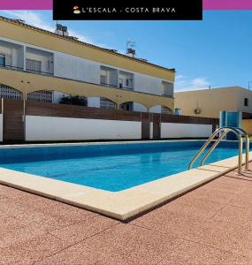 einem Pool vor einem Gebäude in der Unterkunft Casa pareada con piscina in L'Escala
