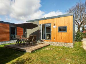 una piccola casa con tavolo, sedie e ombrellone di Holiday Home Tiny Haus Central by Interhome a Beilngries