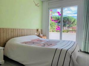 Schlafzimmer mit einem großen Bett und einem Fenster in der Unterkunft Casa pareada con piscina in L'Escala