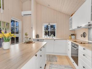 cocina con armarios blancos y encimera de madera en Holiday Home Preben - all inclusive - 50m from the sea by Interhome en Stege