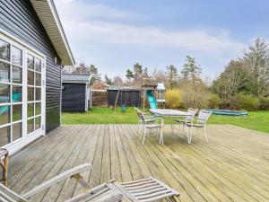a deck with a table and chairs on a house at Holiday Home Kara - all inclusive - 450m from the sea by Interhome in Gilleleje