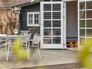 a patio with a white door and chairs and a table at Holiday Home Kara - all inclusive - 450m from the sea by Interhome in Gilleleje