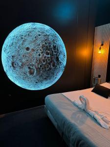 a room with a bed with a visualization of a moon at Fullmoon By Cloud in Aubervilliers