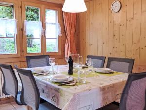 una sala da pranzo con tavolo, sedie e orologio di Apartment Engelhorn by Interhome a Innertkirchen