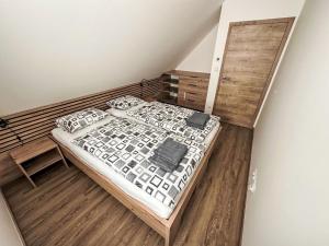 ein Schlafzimmer mit einem Bett und einem Holzboden in der Unterkunft Holiday Home Chalupa 13ka by Interhome in Smržovka