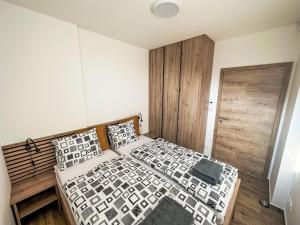 a bedroom with two beds and a wooden door at Holiday Home Chalupa 13ka by Interhome in Smržovka