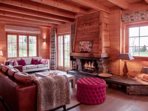 a living room with a fireplace in a log cabin at Chalet Chalet Olivier by Interhome in Villars-sur-Ollon