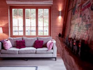 a couch with pillows in a room with a window at Chalet Chalet Olivier by Interhome in Villars-sur-Ollon