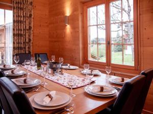 a wooden table with glasses and plates on it at Chalet Chalet Olivier by Interhome in Villars-sur-Ollon