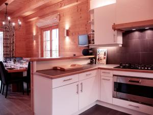 a kitchen with white cabinets and a dining table at Chalet Chalet Olivier by Interhome in Villars-sur-Ollon