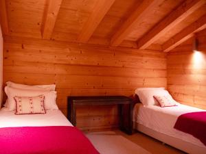 a room with two beds in a log cabin at Chalet Chalet Olivier by Interhome in Villars-sur-Ollon