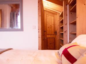 a bedroom with a bed and a wooden door at Chalet Chalet Olivier by Interhome in Villars-sur-Ollon