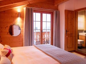 a bedroom with a bed and a large window at Chalet Chalet Olivier by Interhome in Villars-sur-Ollon