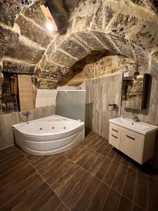 a large bathroom with a tub and a sink at Tokmak Konukevi in Avanos