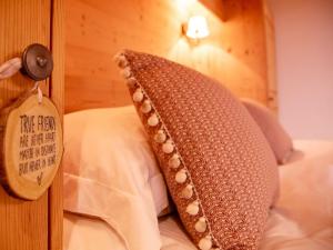 a pillow on a bed with a tag on a wall at Chalet Chalet Olivier by Interhome in Villars-sur-Ollon