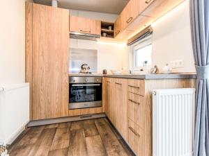 cocina con armarios de madera y fogones en Holiday Home Tiny Haus Altmühlpanorama by Interhome en Beilngries