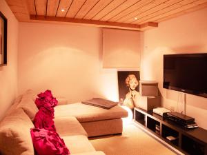 a living room with a couch and a television at Chalet Chalet Olivier by Interhome in Villars-sur-Ollon