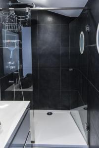 La salle de bains est pourvue d'une douche avec du carrelage noir. dans l'établissement Apartment Key Point by Interhome, à Blankenberge