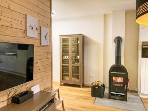 ein Wohnzimmer mit einem Holzofen im Zimmer in der Unterkunft Apartment Stieglitz by Interhome in Hochrindl