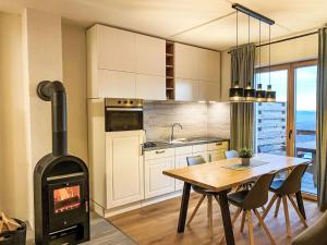 eine Küche und ein Esszimmer mit einem Holzofen im Zimmer in der Unterkunft Apartment Stieglitz by Interhome in Hochrindl