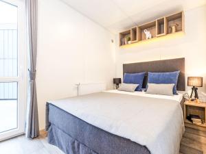 a bedroom with a large bed with blue pillows at Holiday Home Tiny Haus Sonnendeck by Interhome in Beilngries