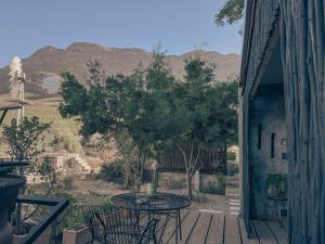 a patio with a table and chairs on a porch at StarsHollow Cottage in Riebeek-Wes