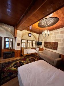 a bedroom with a bed and a couch and a chandelier at Tokmak Konukevi in Avanos