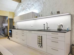 una cucina con armadi bianchi e lavandino di Apartment Winzerhaus by Interhome a Ligerz