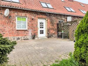 a brick house with a white door and a brick yard at Apartment Kranich by Interhome in Granzin