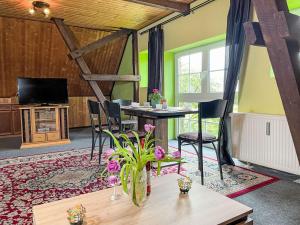 a dining room with a table and chairs and a tv at Apartment Kranich by Interhome in Granzin +21 photos