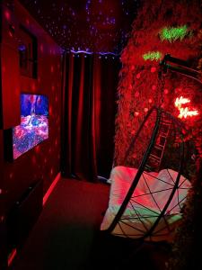 ein rotes Zimmer mit einem Bett und einem TV in der Unterkunft Fullmoon By Cloud in Aubervilliers