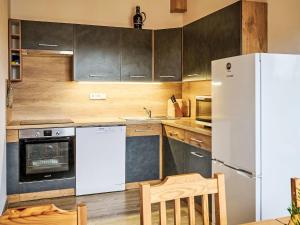 una cucina con frigorifero bianco e armadietti in legno di Apartment Pod Černou Studnicí-3 by Interhome a Nova Ves nad Nisou