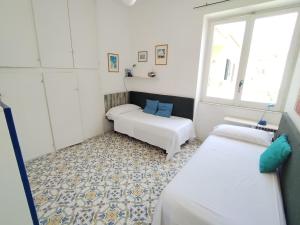 a small room with two beds and a window at Casa Franco in Ischia Town