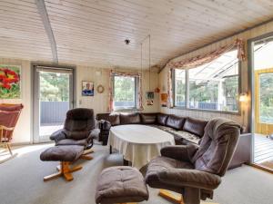 een woonkamer met een bank, stoelen en een tafel bij Holiday Home Tala - all inclusive - 4km from the sea by Interhome in Blåvand