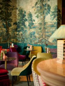 un restaurant avec des chaises colorées et du papier peint dans l'établissement Hotel Damier Kortrijk, à Courtrai