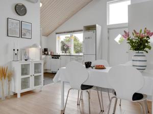 cocina blanca con mesa blanca y sillas en Holiday Home Jörgen - all inclusive - 100m from the sea by Interhome, en Esbjerg