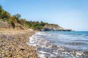 a beach with a rocky shore and the ocean at Paradise Apartments in Ferma