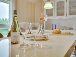 uma garrafa de vinho e dois copos de vinho no balcão da cozinha em Holiday Home Aviaja - all inclusive - 12km from the sea by Interhome em Oksbøl