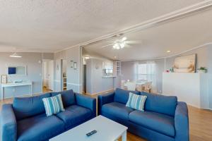 un soggiorno con divano blu e tavolo di Reel Paradise ad Atlantic Beach