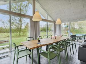 a dining room with a wooden table and chairs at Holiday Home Sada - all inclusive - 12km from the sea by Interhome in Oksbøl