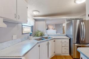 una cucina bianca con lavandino e frigorifero di Reel Paradise ad Atlantic Beach