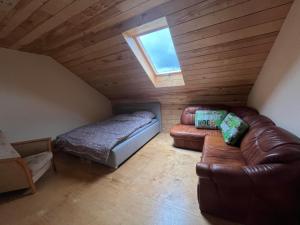 a attic room with a bed and a couch at Domki nad rzeką in Obrocz