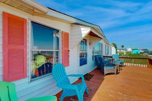 una veranda con sedie blu e una finestra di Reel Paradise ad Atlantic Beach