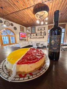 Tokmak Konukevi في أفانوس: قطعة من الكعك على طاولة بجوار زجاجة من النبيذ
