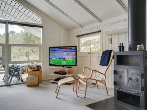 uma sala de estar com uma televisão de ecrã plano e cadeiras em Holiday Home Jannick - all inclusive - 1-5km from the sea by Interhome em Blåvand