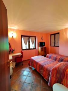 Habitación de hotel con 2 camas y escritorio en Al Boschetto, en Melizzano