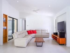 a living room with a white couch and a tv at Amazing House Big Swimming Pool BBQ in Mooloolah
