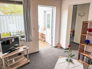 a living room with a flat screen tv and a door at Holiday Home Weller by Interhome in Ostseebad Koserow +14 photos