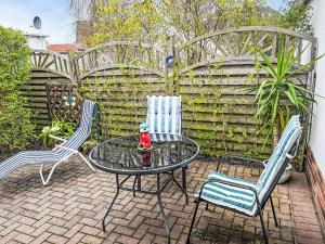 a patio with two chairs and a table with a drink on it at Holiday Home Weller by Interhome in Ostseebad Koserow